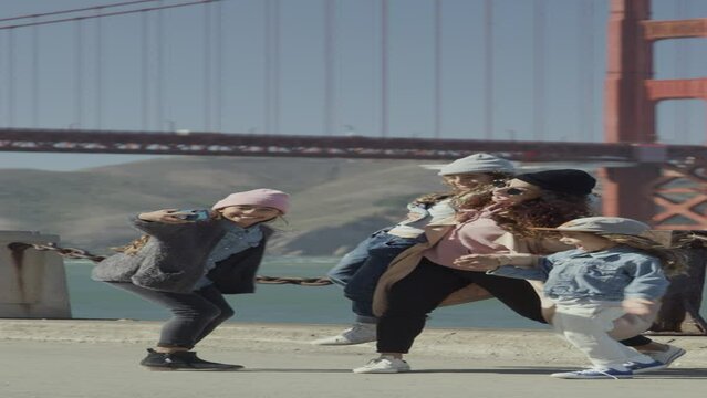 Mother and children walking near Golden Gate Bridge then posing for a cell phone selfie  - vertical video / San Francisco, California, United States