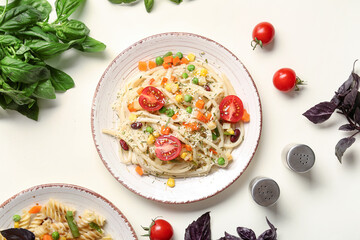 Plates with tasty pasta primavera on white background