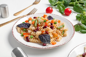 Plate with tasty pasta primavera on white background