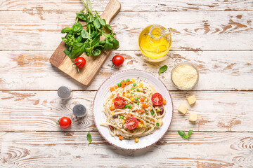 Plate with tasty pasta primavera and ingredients on white wooden  background