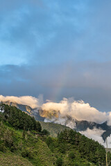 Beautiful view of the rainbow over the  volcanoes in the city of Banos, Ecuador. Amazing sunset.