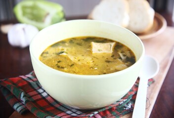 bowl of soup with bread and garlic