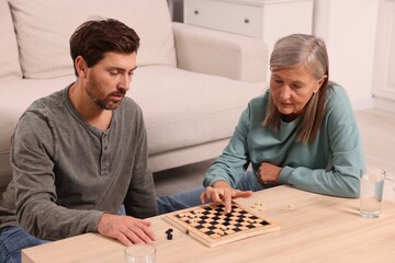 Family playing checkers at coffee table in room