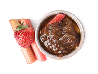 Tasty rhubarb jam in bowl, cut stems and strawberry on white background, top view