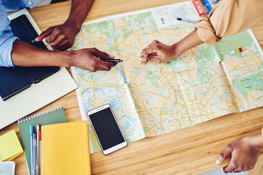 Top view of desktop with map and stationery for planning route of trip
