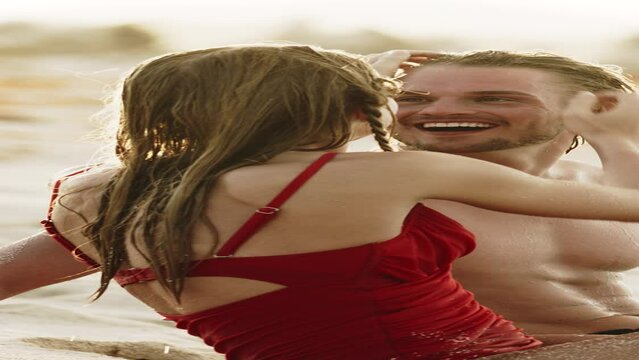 Romantic couple sitting on beach and kissing  - vertical video / Petit Tabac, Tobago Cays, St. Vincent and the Grenadines