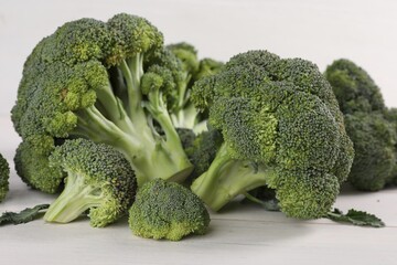 Fresh raw broccoli on white wooden table, closeup