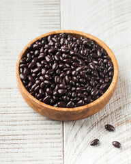 Sunflower seeds in chocolate in a wooden plate on a white background. 