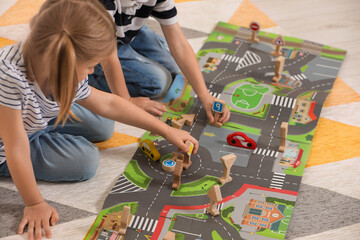 Little children playing with set of wooden road signs and toy cars indoors