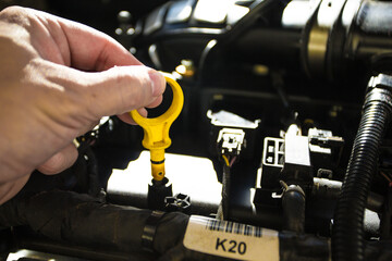 Car engine with oil funnel and checking oil before an oil change for car maintenance