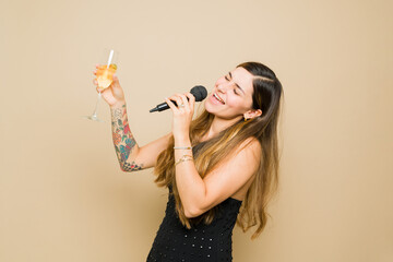 Attractive woman having fun with karaoke and drinking