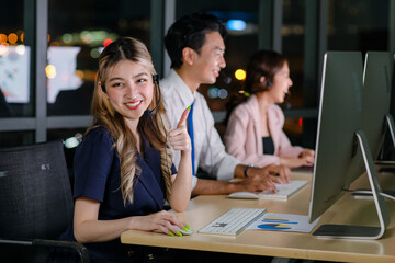 Asian professional successful female businesswomen assistant night shift call center helpline in formal business outfit and microphone headphones sitting smiling talking helping customers online