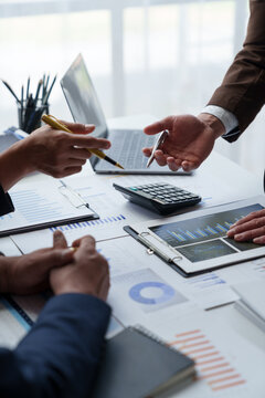 A group of Asian businessmen is meeting to summarize the company's operating results, finances, and profits and losses. Management of startup companies Growing Profitable Management Ideas.