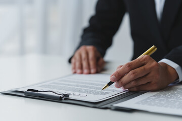 Businessman holding a pen to sign a contract, making a detailed agreement, business contract for finance, real estate, insurance, taxes and signing an official document. - obrazy, fototapety, plakaty