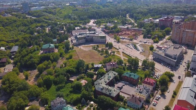 Aerial view of a summer green city, sleeping area. Clip. Ordinary houses and streets with park zones.