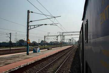 10th October, 2023, Ranigunj, West Bengal, India: Indian Railway train track from a moving train crossing Ranigunj Rail station. Motion blur due to fast moving.