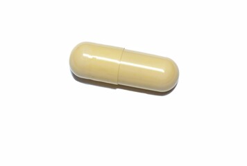 light yellow capsule medicine on a white background