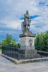 Fototapeta na wymiar Statue of Robert the Bruce on concrete plinth under cloudy sky.