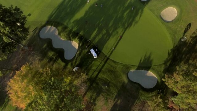 Aerial Backward Tilt Up Shot Of People Playing Golf On Course By Trees Against Sky - Manhasset, New York