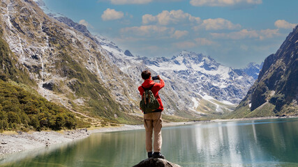 Backpack young man using smartphone take picture  nature of view at lake tekapo ,New zealand