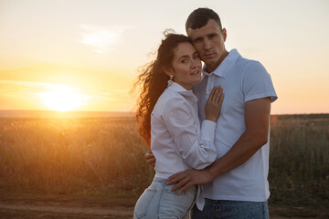 Trust harmony and devotion in relationship of loving couple at sunset. Young woman puts hand on man chest. Man gently embraces girlfriend on waist