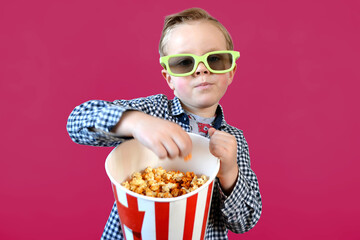 Cute fun kid baby boy 4 year old in red t-shirt holding bucket for popcorn