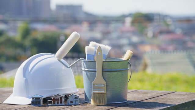 塗装道具とヘルメットと模型の家｜リフォーム・塗装業者 イメージ