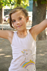Cute kid girl 10 year old posing on nature background. Looking at camera
