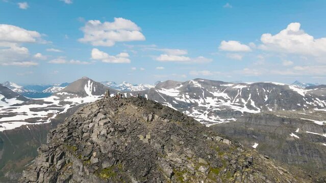 Areal drone footage with people resting after a hike on the peak of Innerdalst&aring;rnet and admiring the wonderful panorama of the Innerdal valley, Norway