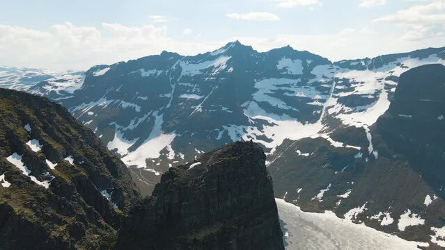 Areal drone footage with people resting after a hike on the peak of Innerdalst&aring;rnet and admiring the wonderful panorama of the Innerdal valley, Norway