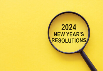 2024 new year resolution - text through magnifying glass on yellow background. Focus on new goals - Powered by Adobe