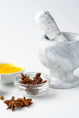 Marble mortar and pestle with spices on white background