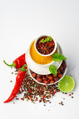 Bowls with spices and cooking ingredients on white background