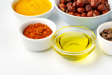 Bowls with spices and cooking ingredients on white background