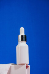 Cosmetic product in tube, bottle, lotion or serum on blue background. 