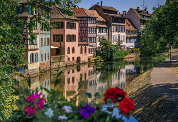 Obraz premium Ornate traditional half timbered houses with blooming flowers along the canals in the picturesque Petite France district of Strasbourg, Alsace, France