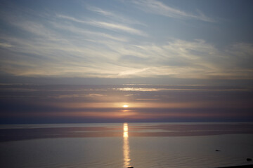 Obraz premium Amazing scenery with sky coloured by the sunset reflecting the calm sea water, selective focus