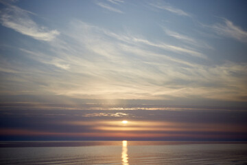 Amazing scenery with sky coloured by the sunset reflecting the calm sea water, selective focus