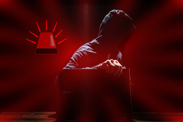 A Hacker with laptop sits at a table and abstract binary code. Business life threat virtual programs.
