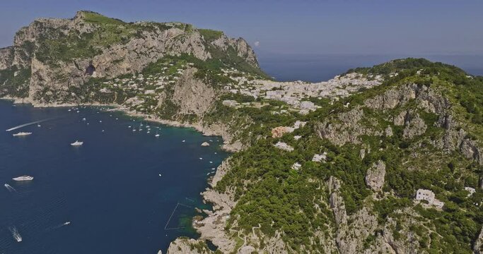 Capri Italy Aerial v7 cinematic drone fly along the sea capturing idyllic charm of coastal beauty, rugged cliffside neighborhoods and quaint island town in summer - Shot with Mavic 3 Cine - May 2023