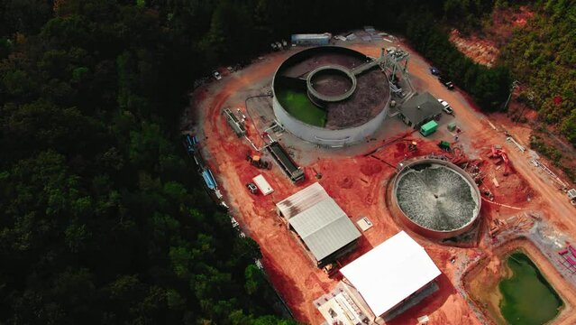 orbiting aerial of wastewater treatment plant in construction with top tank lids open. Chelsea, Alabama, USA