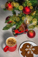 Cookies and a steaming cup of coffee, set against the backdrop of a Christmas tree.