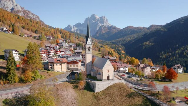 4k drone flight point of view (Ultra High Definition) of San Lorenzo Catholic church. Exciting autumn cityscape of Selva di Cadore village, Province of Belluno, Italy. Traveling concept background..