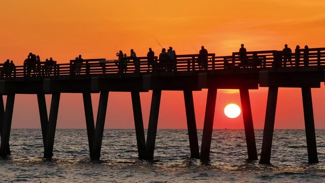 Fishermen enjoying vacation time on Venice fishing pier in Florida. Seaside summer activities