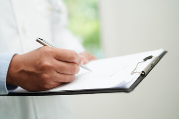 Doctor checking and note diagnosis medicine in clipboard of patients in hospital.
