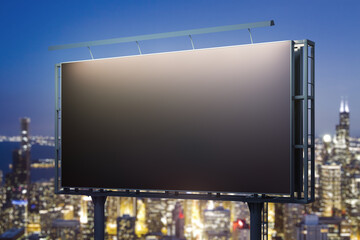 Blank black horizontal billboard on city buildings background at night, perspective view. Mockup, advertising concept