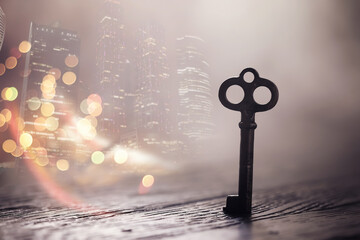 vintage key over old wooden surface with back light. Double exposur night city.