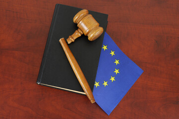 Broken judge gavel and legal book with flag of European Union. Problems in EU laws concept.