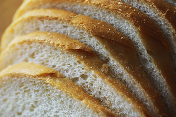 long loaf on a wooden board and knife isolated on a white background. Tasty bread