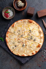 Pizza with pear and gorgonzola cheese and honey on a dark background. Top view